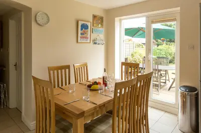 a dining room with a wooden table and chairs at 18 Pilgrim’s Way in Thorpeness