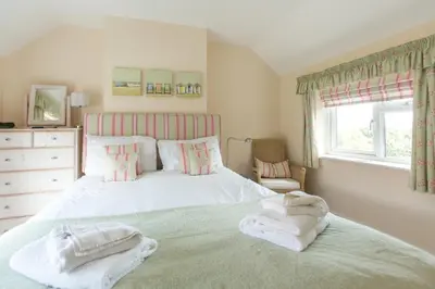 a bedroom with a bed with towels on it at 18 Pilgrim’s Way in Thorpeness