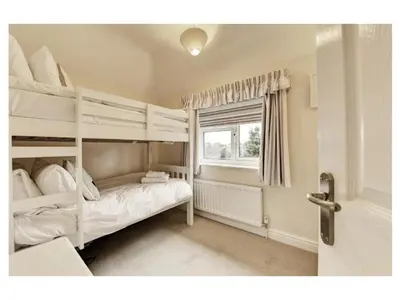 a bedroom with two bunk beds and a window at 18 Pilgrim’s Way in Thorpeness
