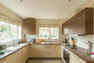 a kitchen with wooden cabinets and a sink at 18 Pilgrim’s Way in Thorpeness