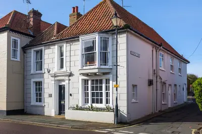 a white house with a red roof on a street at The Old Gordon House - High Street location close to the beach and town amenities - Aldeburgh Coastal Cottages in Aldeburgh