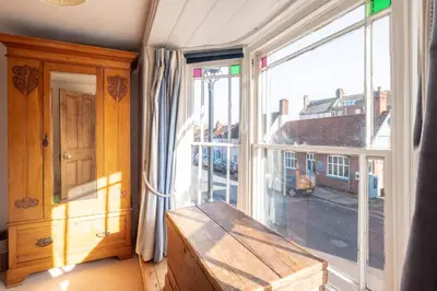 a room with a window with a wooden bench next to it at The Old Gordon House - High Street location close to the beach and town amenities - Aldeburgh Coastal Cottages in Aldeburgh