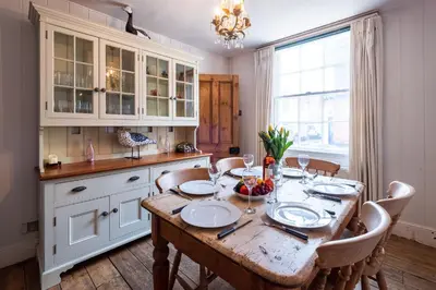 a dining room with a table and chairs and a kitchen at The Old Gordon House - High Street location close to the beach and town amenities - Aldeburgh Coastal Cottages in Aldeburgh