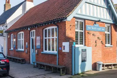 a brick building with benches in front of it at The Old Gordon House - High Street location close to the beach and town amenities - Aldeburgh Coastal Cottages in Aldeburgh