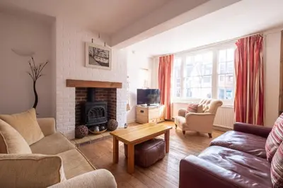 a living room with a couch and a fireplace at The Old Gordon House - High Street location close to the beach and town amenities - Aldeburgh Coastal Cottages in Aldeburgh