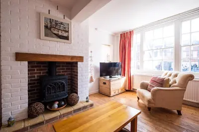 a living room with a fireplace and a couch and a tv at The Old Gordon House - High Street location close to the beach and town amenities - Aldeburgh Coastal Cottages in Aldeburgh