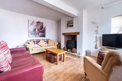 a living room with a couch and a fireplace at The Old Gordon House - High Street location close to the beach and town amenities - Aldeburgh Coastal Cottages in Aldeburgh