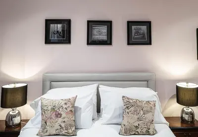 a bedroom with a bed with three pictures on the wall at Beautiful Country House Apartment in Newmarket