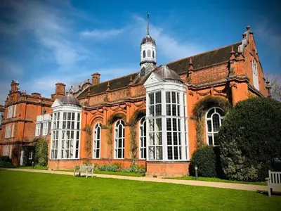 a large red brick building with white windows at Newnham College - University of Cambridge in Cambridge