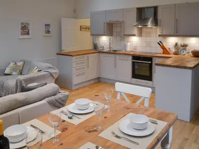 a kitchen and living room with a table and a couch at Blyth Green Stable in Long Stratton
