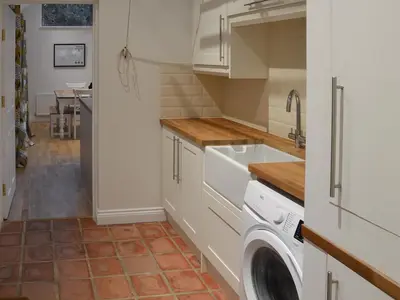 a kitchen with a sink and a washing machine at Blyth Green Stable in Long Stratton