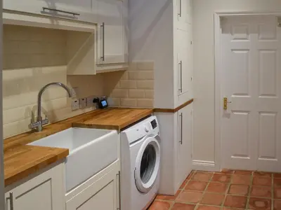 a kitchen with a washing machine and a sink at Blyth Green Stable in Long Stratton