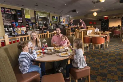 a family sitting at a table in a restaurant at Mikanda Lodge in Clacton-on-Sea