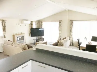 a living room with a couch and a tv at Mikanda Lodge in Clacton-on-Sea