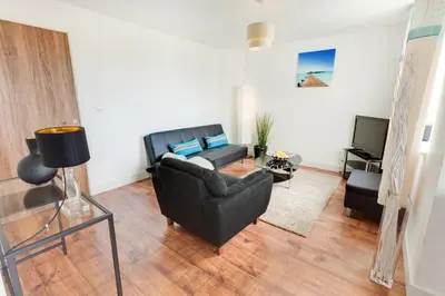 a living room with a couch and a television at Meridian Apartment Suites in Southend-on-Sea