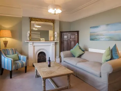 a living room with a couch and a fireplace at 14 Market Cross Place - Beachfront location with lovely sea views - Aldeburgh Coastal Cottages in Aldeburgh