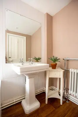 a bathroom with a white sink and a mirror at 14 Market Cross Place - Beachfront location with lovely sea views - Aldeburgh Coastal Cottages in Aldeburgh