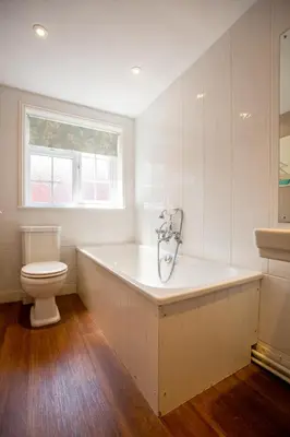 a white bathroom with a tub and a toilet at 14 Market Cross Place - Beachfront location with lovely sea views - Aldeburgh Coastal Cottages in Aldeburgh
