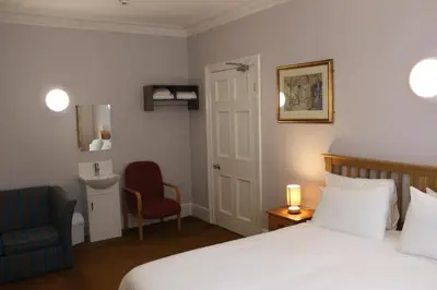 a hotel room with a bed and a chair at Brookside Lodge in Baldock