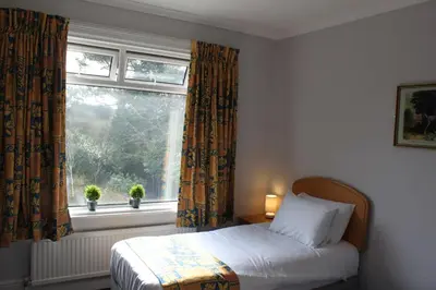 a bedroom with a bed in front of a window at Brookside Lodge in Baldock