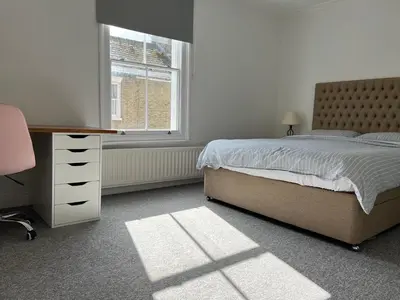 a bedroom with a bed and a desk and a window at 200m To Botanical Garden 3 Bedroom Victoria House in Cambridge