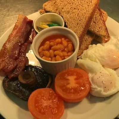 a plate of breakfast food with eggs bacon beans and toast at The Nags Head in Norwich