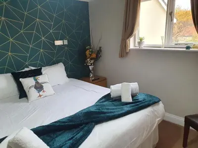 a bedroom with a bed with a blue wall at The Nags Head in Norwich