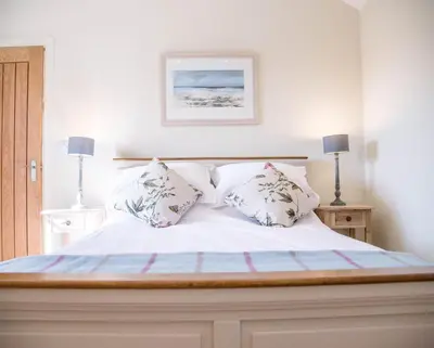 a white bed with two pillows on top of it at Hill Stables, Ufford in Ufford