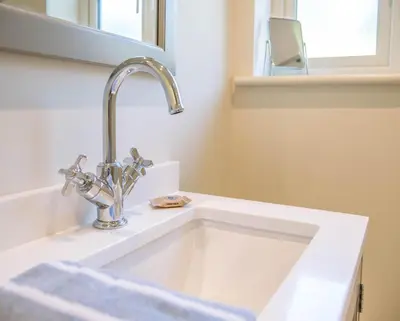 a white sink with a faucet in a bathroom at Hill Stables, Ufford in Ufford