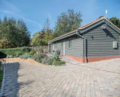 a house with a brick driveway in front of it at Hill Stables, Ufford in Ufford