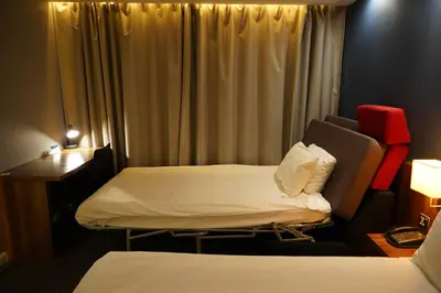 a hotel room with two beds and a desk at Holiday Inn Express Harlow by IHG in Harlow