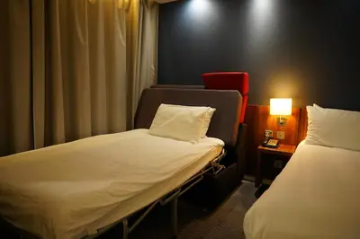a hotel room with two beds and a table with a lamp at Holiday Inn Express Harlow by IHG in Harlow