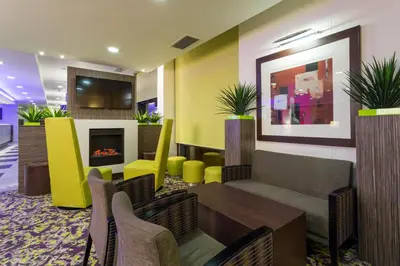 a lobby with a table and chairs and a fireplace at Holiday Inn Express Harlow by IHG in Harlow