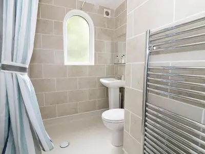 a bathroom with a toilet and a window at Flat 1, Cambridge Court in Frinton-on-Sea