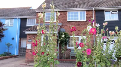 a brick house with flowers in front of it at Poplars in Aldeburgh