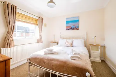 a bedroom with a bed with towels on it at Poplars in Aldeburgh