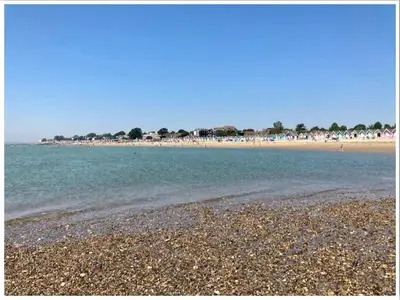 a beach with a rocky shore and the ocean at The Mariners Suite in West Mersea