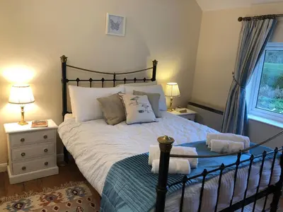 a bedroom with a large bed and a window at Marsh View Cottage, Aldeburgh in Aldeburgh