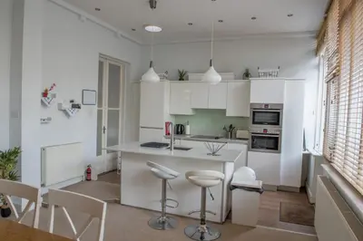 a kitchen with white cabinets and bar stools at Toothbrush Apartments - Central Ipswich - Fonnereau Road in Ipswich