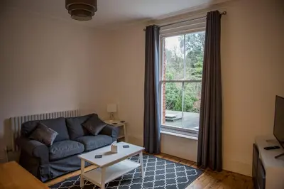 a living room with a couch and a large window at Toothbrush Apartments - Central Ipswich - Fonnereau Road in Ipswich
