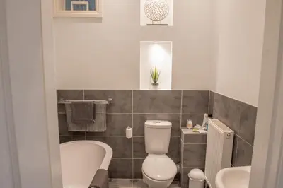 a bathroom with a toilet and a tub and a sink at Toothbrush Apartments - Central Ipswich - Fonnereau Road in Ipswich