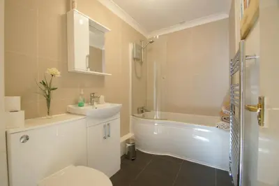 a bathroom with a toilet and a sink and a tub at 1 WATER PUMP HOUSE in Bury Saint Edmunds