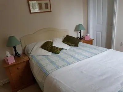 a bedroom with a bed with two nightstands and two lamps at The Brambles B&B in Waterbeach