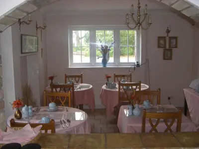 a dining room with tables and chairs with pink table cloth at The Brambles B&B in Waterbeach