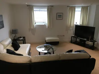 a living room with two couches and a tv at Toothbrush Apartments - Ipswich Waterfront - The Cambria in Ipswich