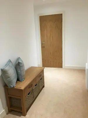 a room with a wooden table and a door at Toothbrush Apartments - Ipswich Waterfront - The Cambria in Ipswich