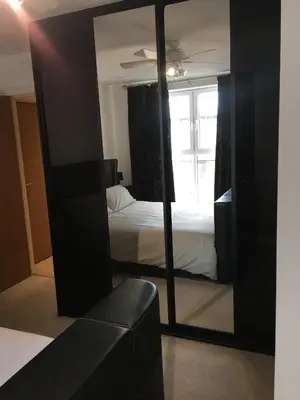 a mirror in a room with a bed and a bedroom at Toothbrush Apartments - Ipswich Waterfront - The Cambria in Ipswich