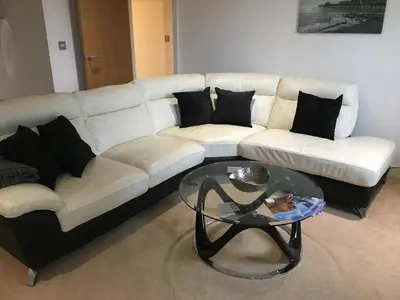 a living room with a white couch and a glass table at Toothbrush Apartments - Ipswich Waterfront - The Cambria in Ipswich