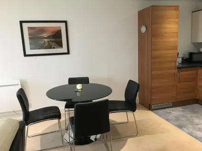 a dining room with a table and black chairs at Toothbrush Apartments - Ipswich Waterfront - The Cambria in Ipswich