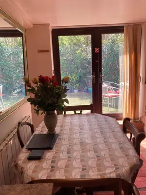 a dining room table with a vase of flowers on it at 2 bedrooms Bell Cottage in Hoddesdon